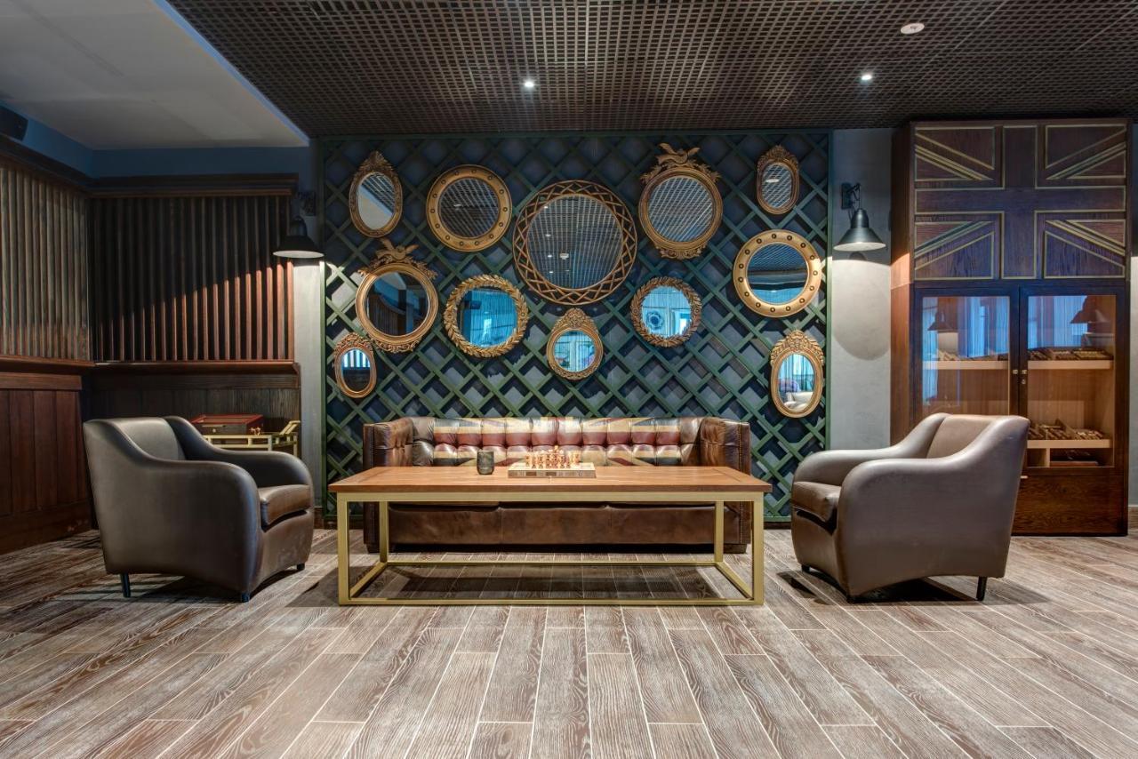 Dukes The Palm, A Royal Hideaway Hotel Dubai Exterior foto The photo features a stylish and inviting interior space. In the center, there's a brown leather sofa with a tufted design and a wooden coffee table in front of it. To either side of the sofa, there are two elegant armchairs, also in a muted color. 
