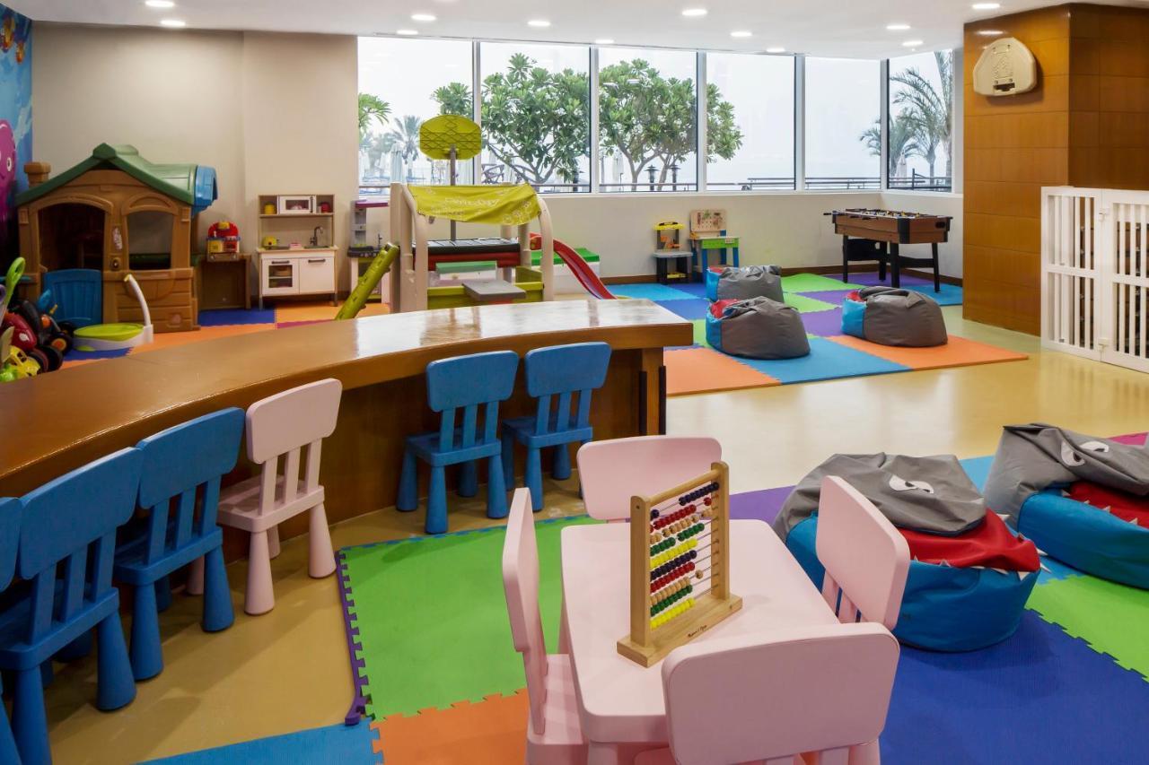 Dukes The Palm, A Royal Hideaway Hotel Dubai Exterior foto The photo shows a colorful indoor play area designed for children. The space features several elements, including:

- **Play Structures**: There is a small climbing structure with slides, along with a playhouse.
- **Furniture**: Brightly colored tabl