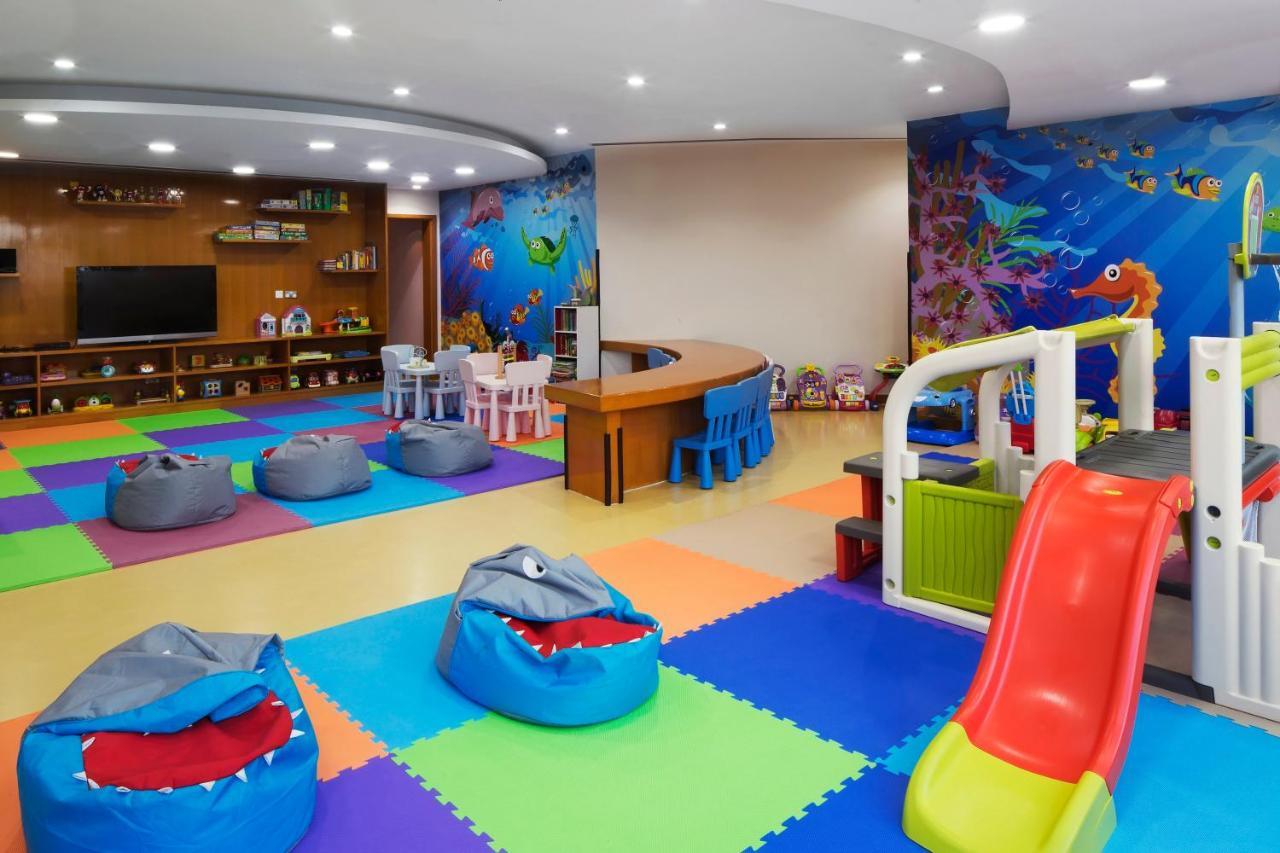 Dukes The Palm, A Royal Hideaway Hotel Dubai Exterior foto The photo shows a colorful children's playroom designed for fun and engagement. The flooring has various colored mats, creating a vibrant and safe environment for kids. 

In the center, there are several bean bags shaped like sharks, adding a playful