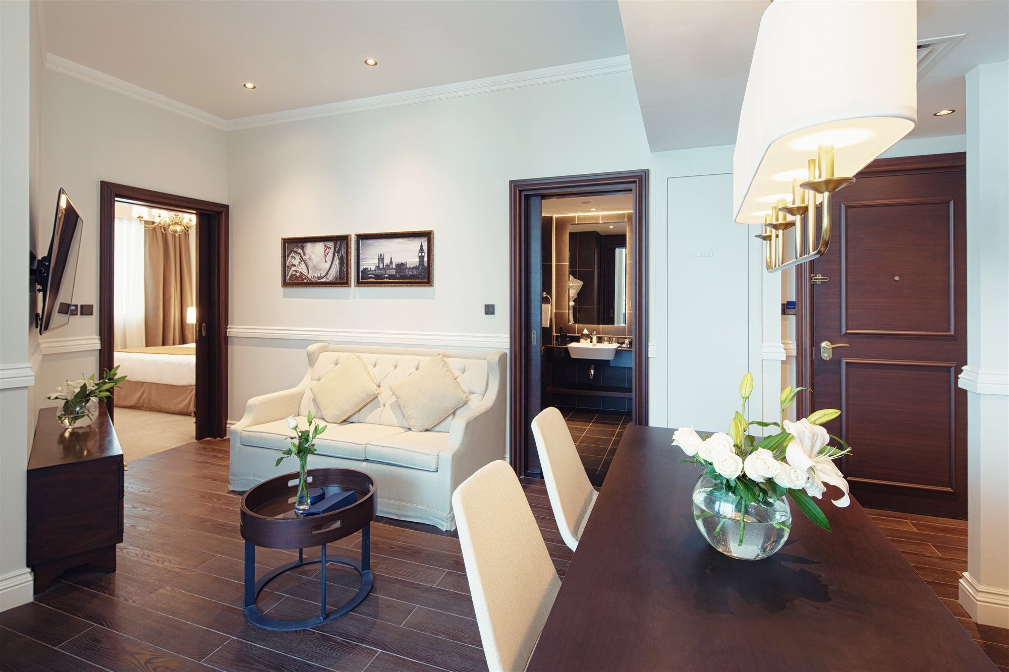 Dukes The Palm, A Royal Hideaway Hotel Dubai Exterior foto The photo shows a stylish hotel suite or living area. You can see a comfortable light-colored sofa with decorative cushions, positioned next to a small round coffee table. There are two framed artworks on the wall, adding a touch of decor. Directly a
